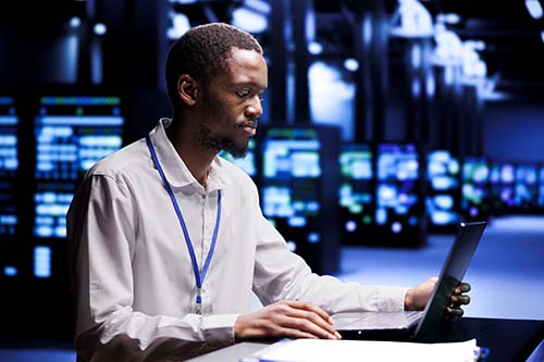 Technician ordering servers racks with high availability features to ensure continuous operation in data center. Specialist installing redundant power supplies and network interfaces